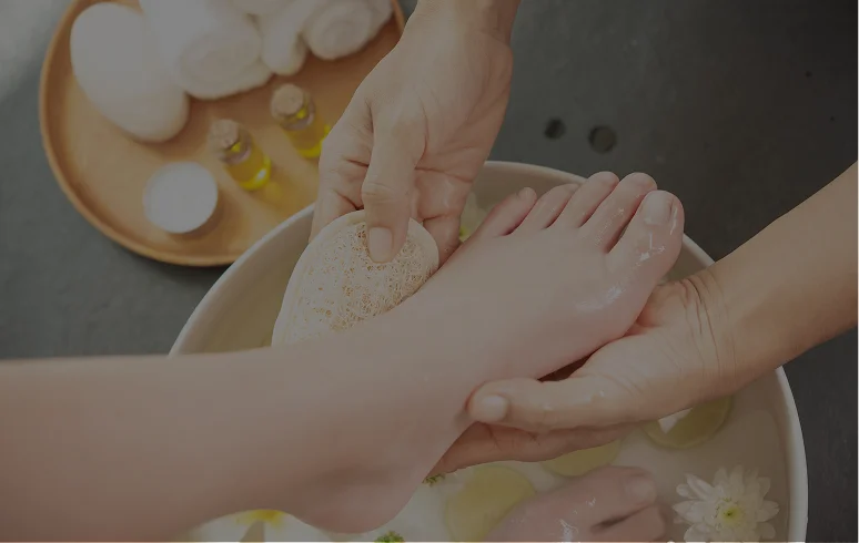 Client feet in a pipeless spa pedicure basin with milk bath and flower petals at a Las Vegas nail salon
