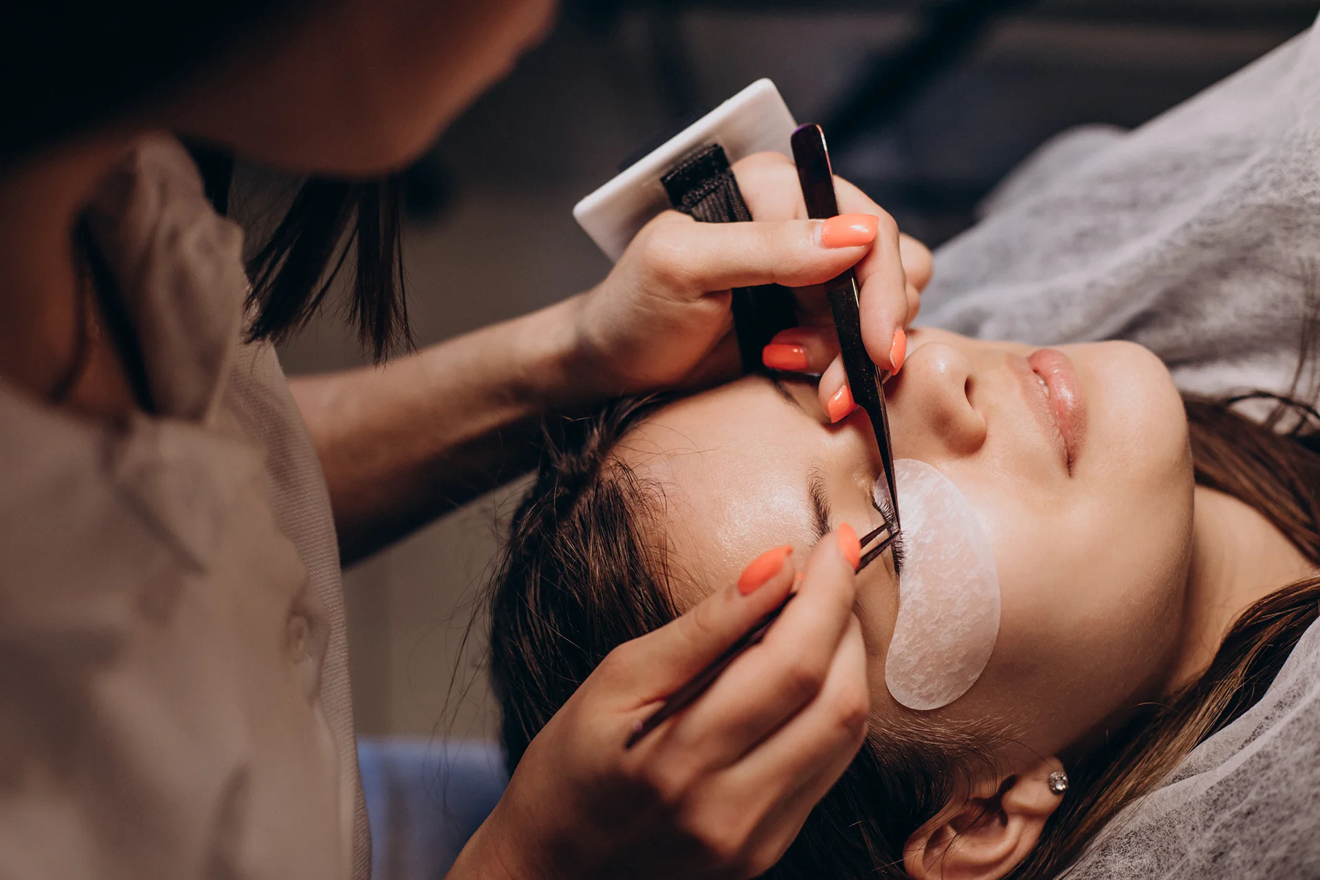 Lash artist applying eyelash extensions with tweezers to a client at a Las Vegas salon